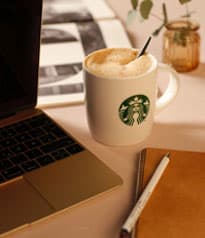 Starbucks Tasse neben Laptop